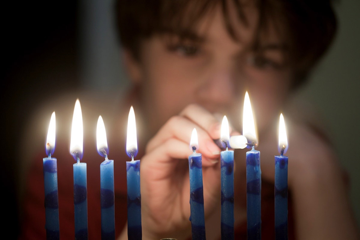 Boy lighting Menorah