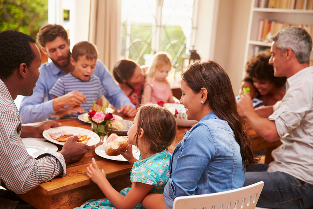 Friends and Family Sitting Around a Table Eating