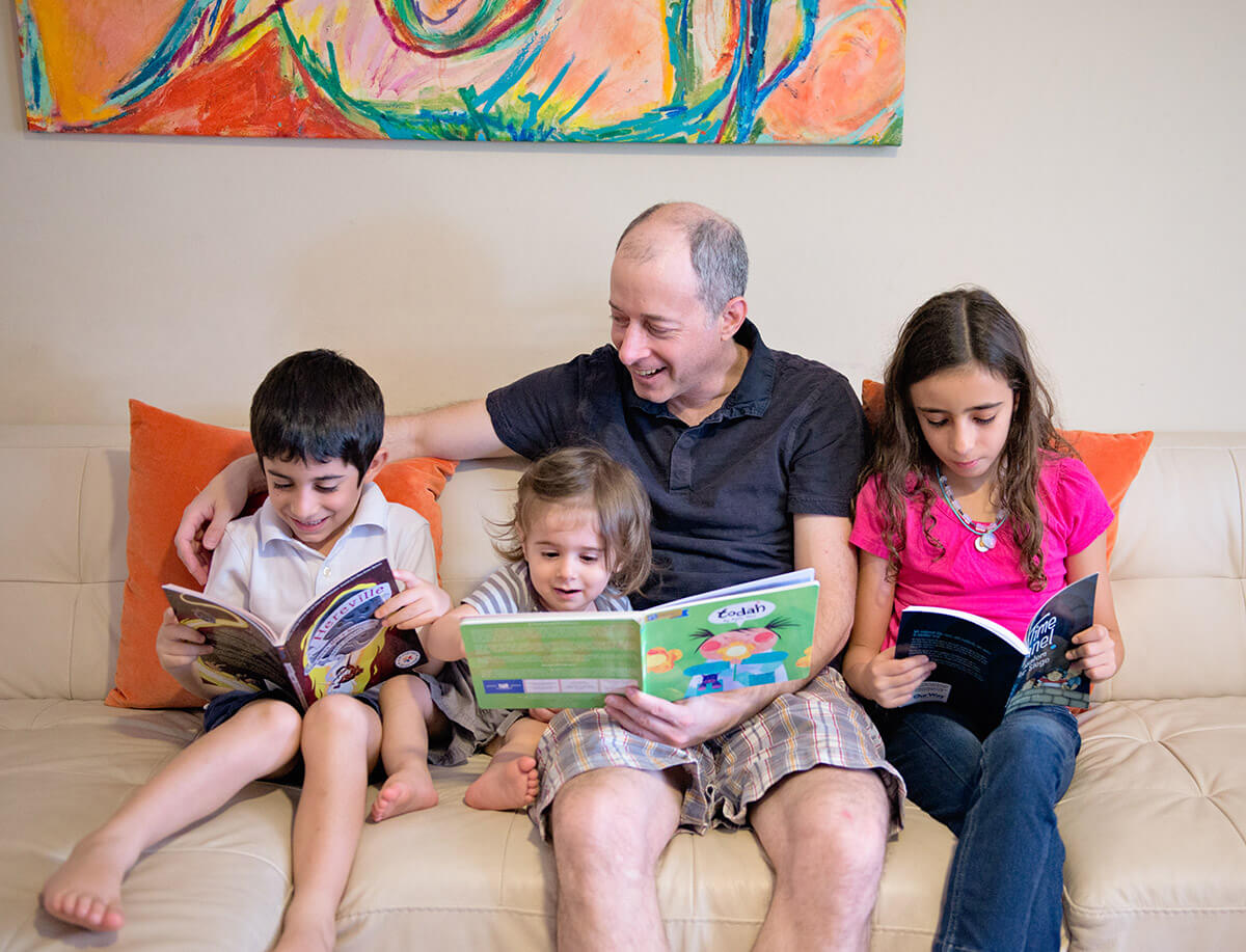 Family sitting on the couch reading PJOW books